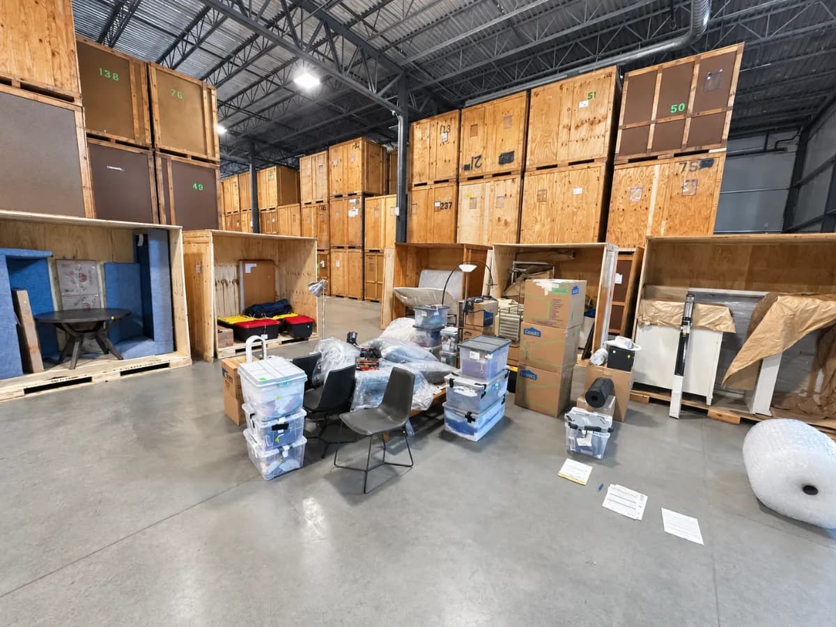 Organized wooden storage vaults and wrapped belongings inside a moving warehouse