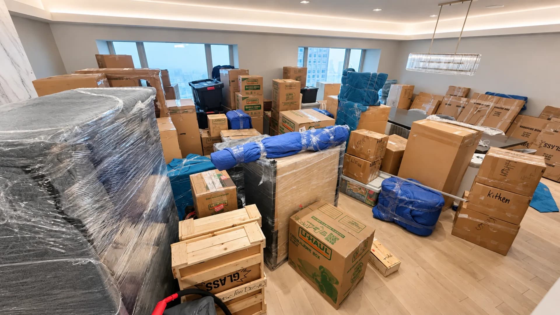 A bright room filled with wrapped furniture and moving boxes during a move