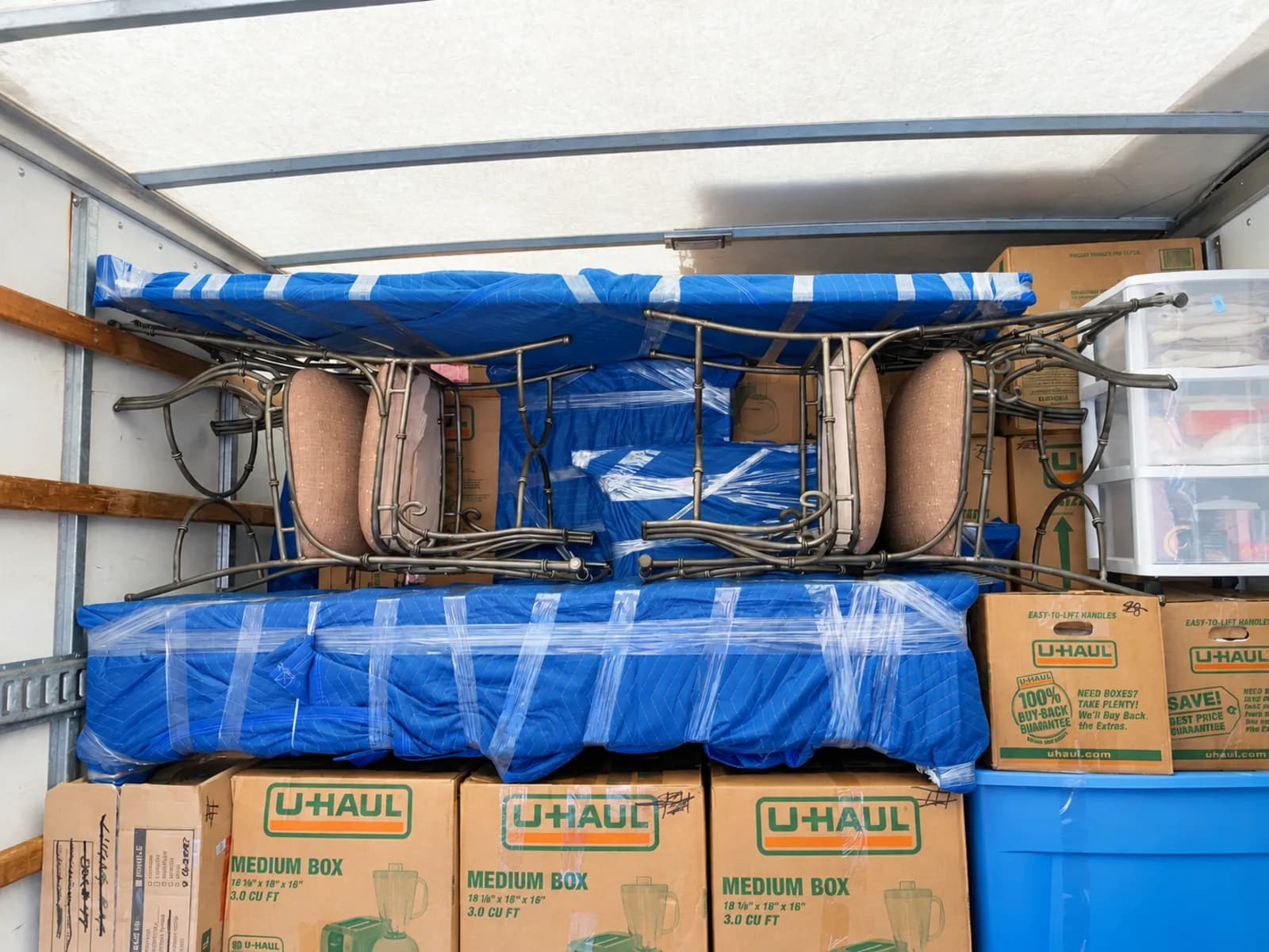 Boxes and padded furniture strapped in place inside a moving truck
